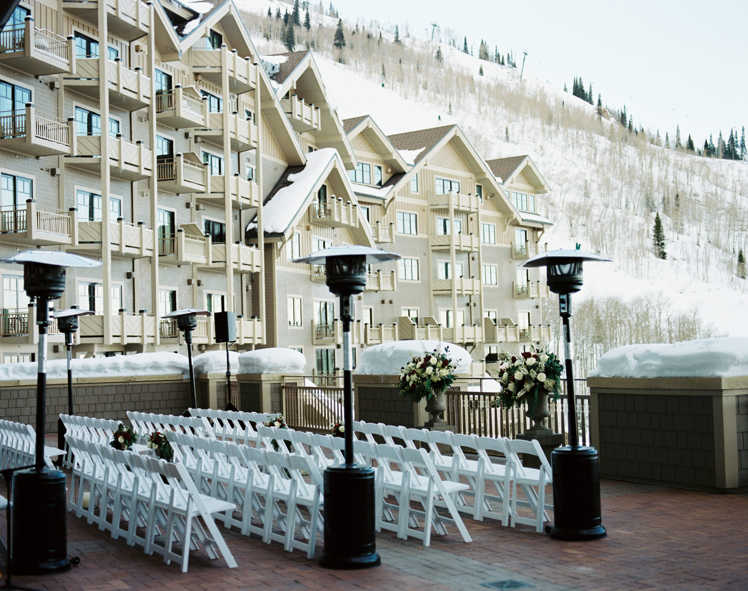 This Park City winter wedding held an outside ceremony was at Montage Deer Valley. The seating overlooked white snowy mountains. At the end of each aisle they had heaters to make sure guests were comfortable and warm.