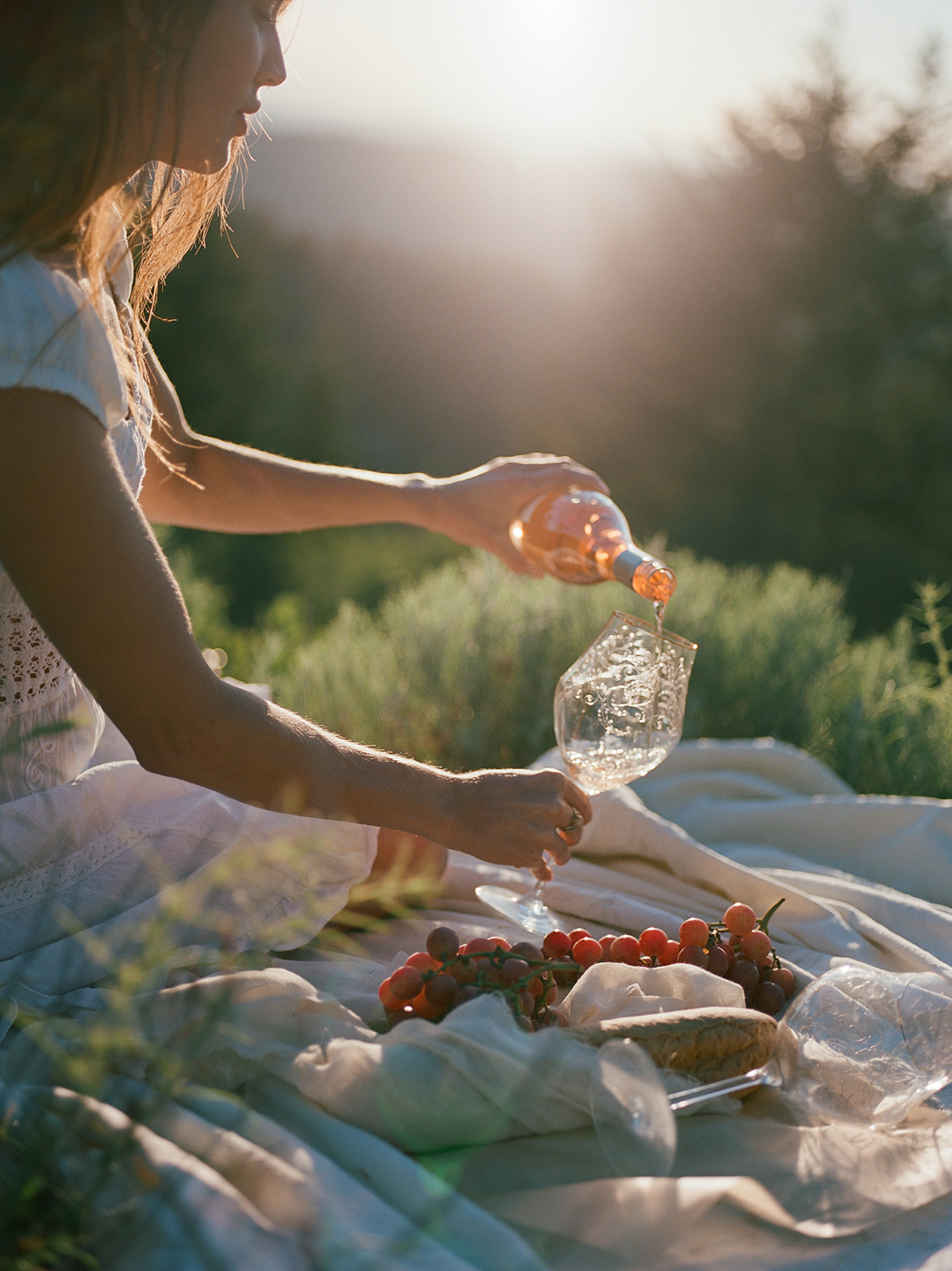 Woman pours wine at a picnic in the hills of the pacific northwest. 