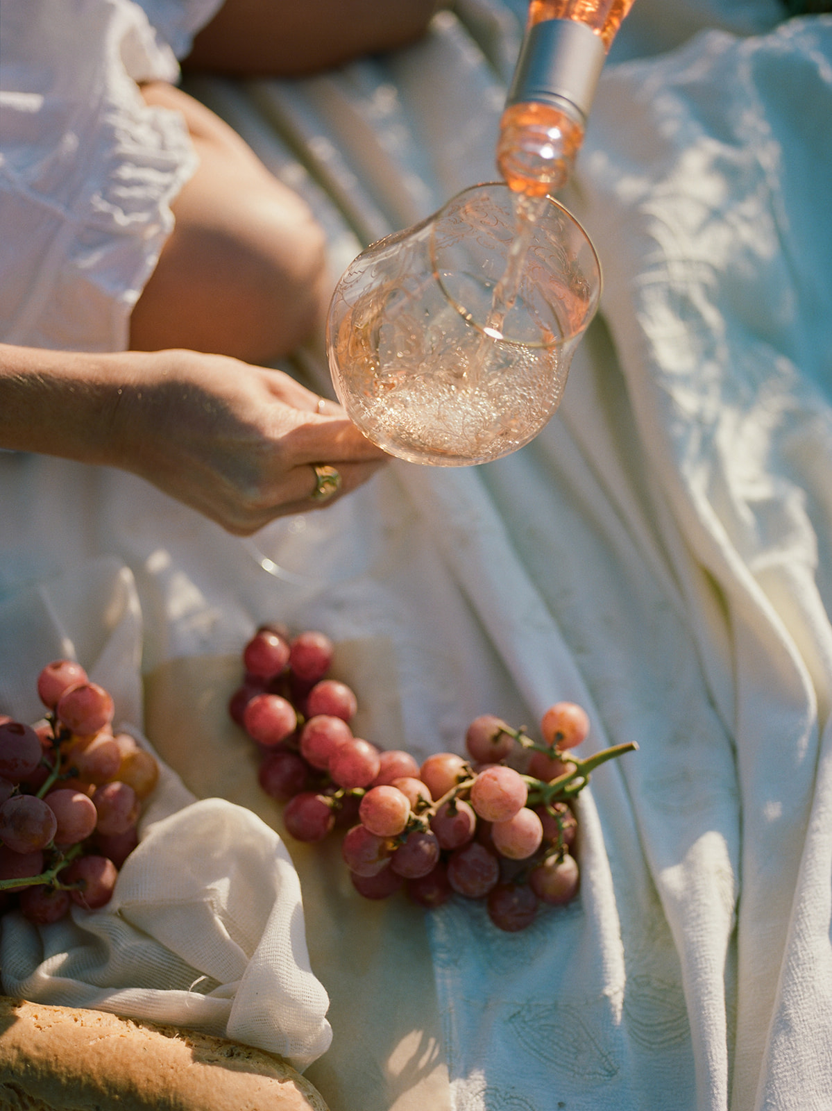 Woman pours wine for a summer photo shoot. 