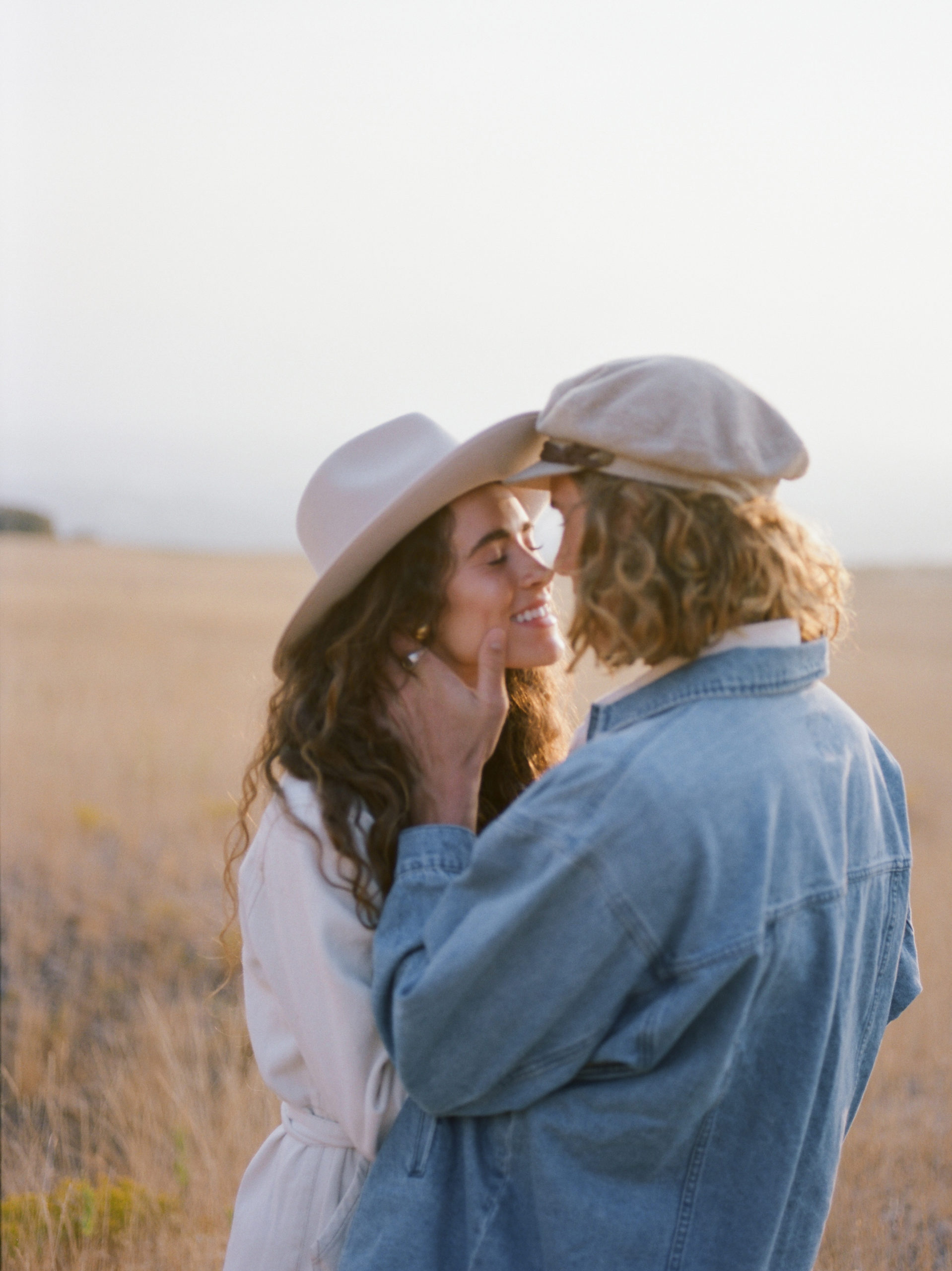 A female with brunette long hair and a male with short blonde hair couple posing for their engagement photos in their Utah location.