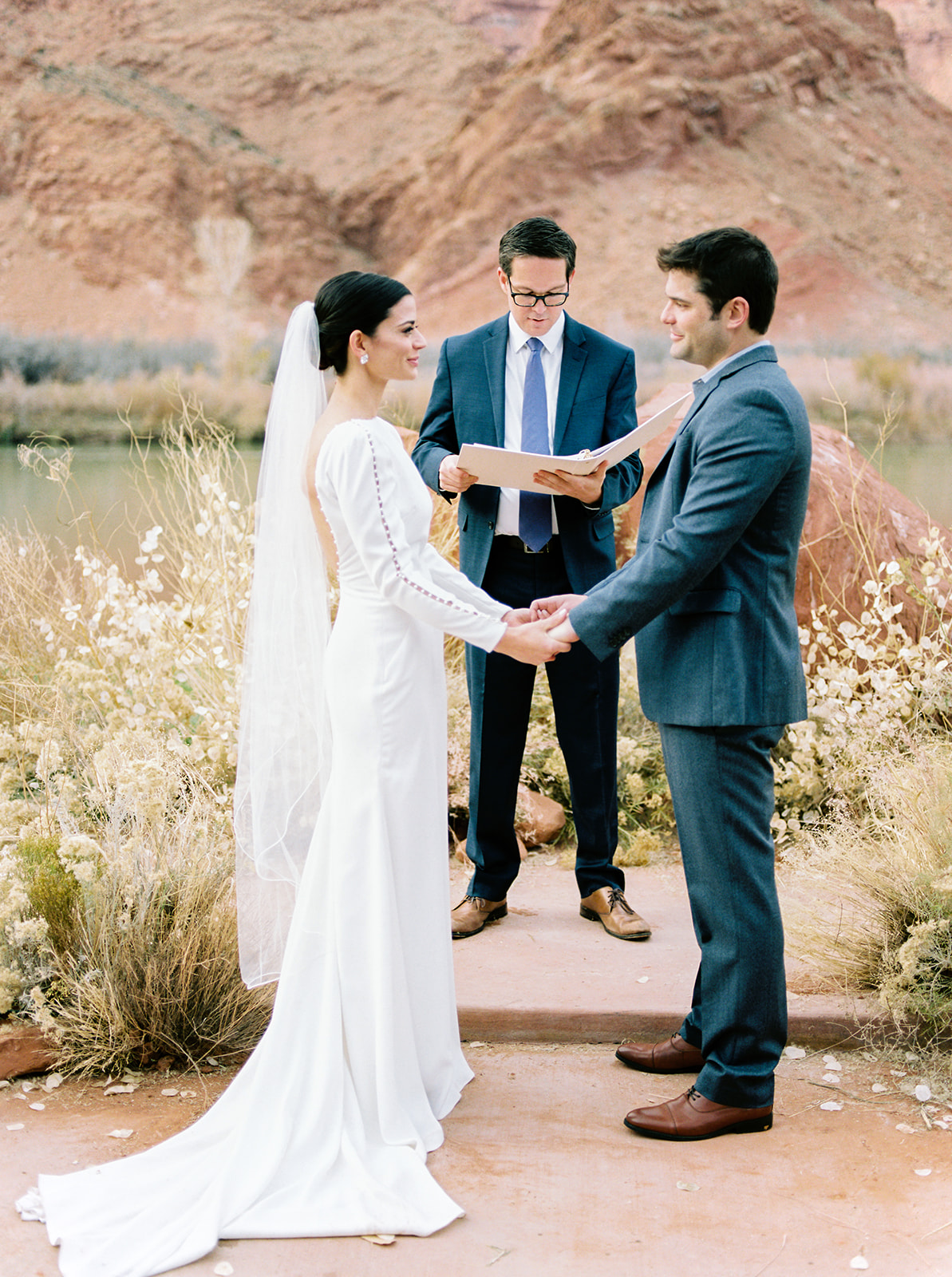 bride and groom exchange vows at their intimate destination wedding in moab utah