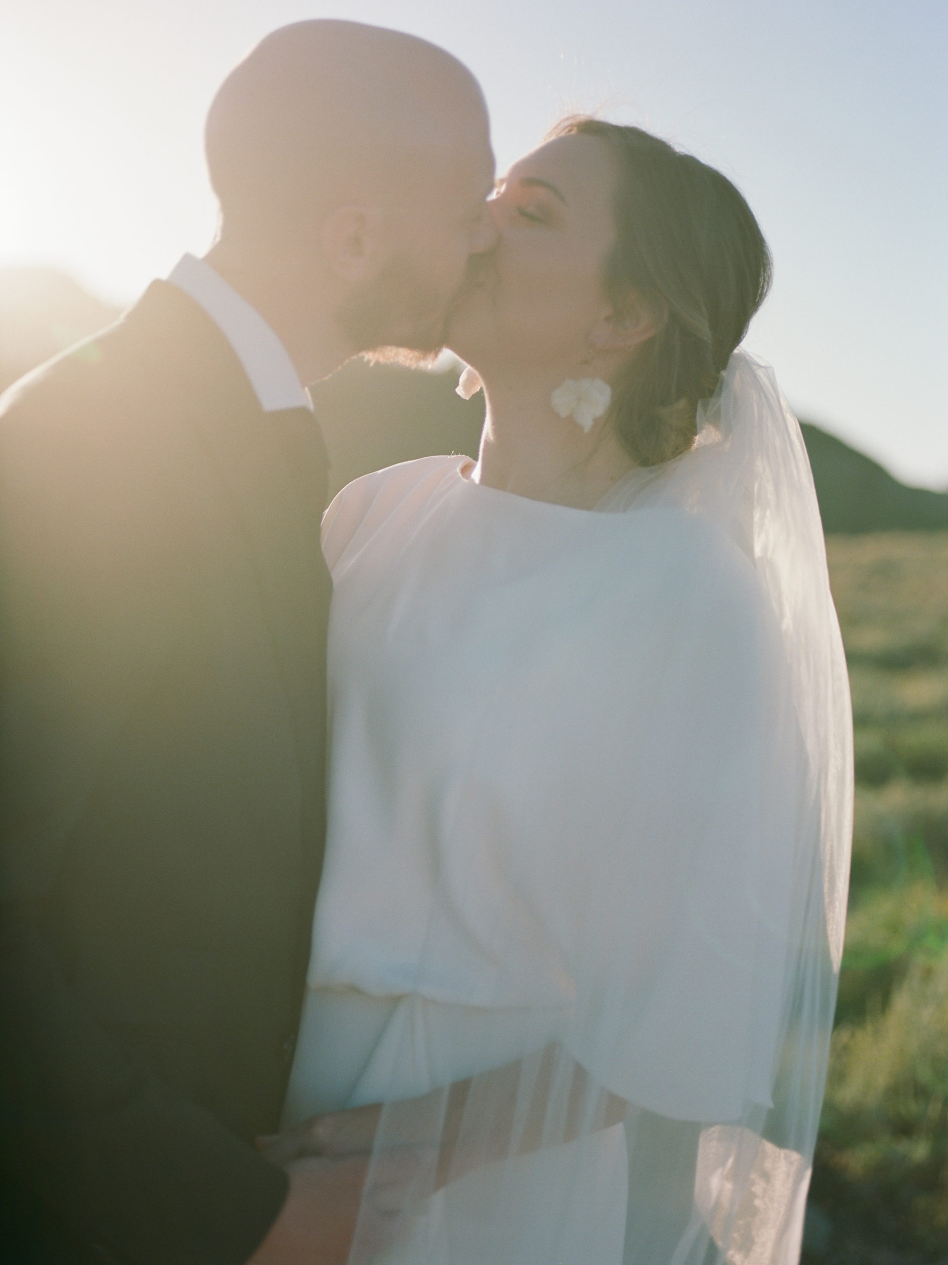 bride and groom portraits kissing sunset photos