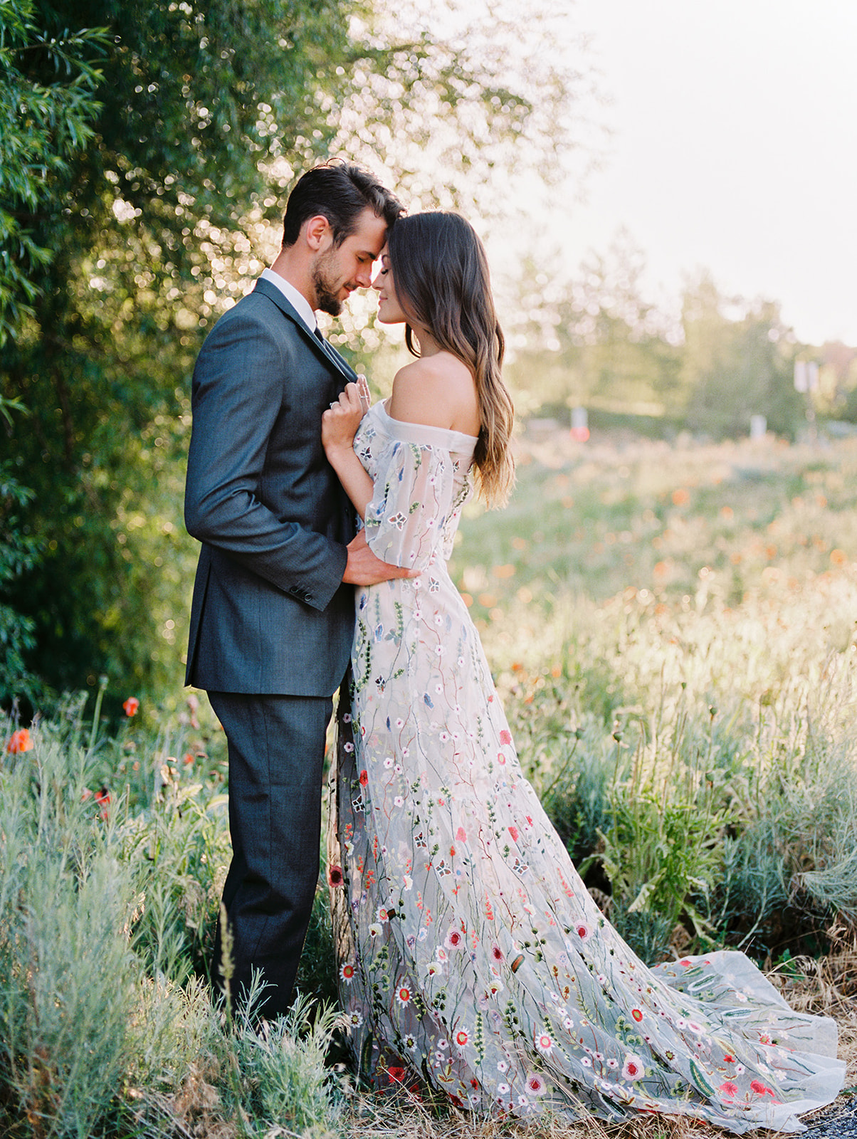 groom with his bride wearing an embroidered floral wedding dress 