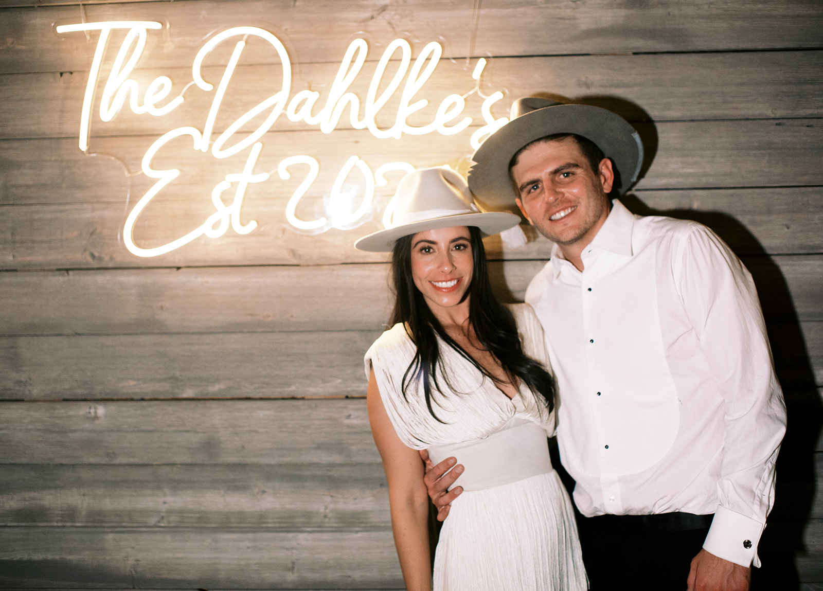 a bride and groom pose by a wedding neon sign at their blue sky ranch wedding reception in wanship utah. photo by megan robinson photography