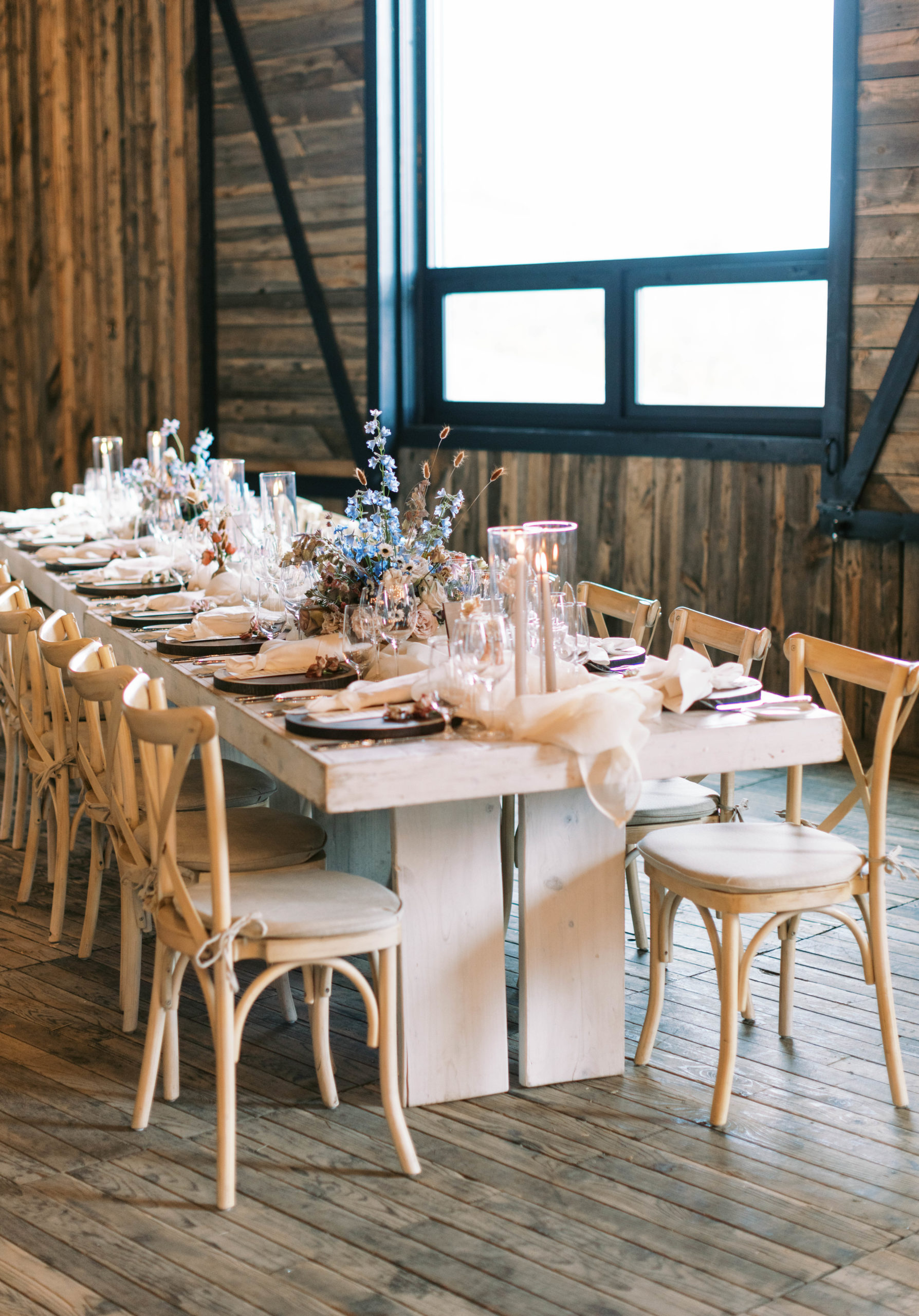 wedding table place setting with a custom menu, wooden chargers, and wildflower wedding centerpieces for an eclectic utah ranch wedding. photo by megan robinson photography