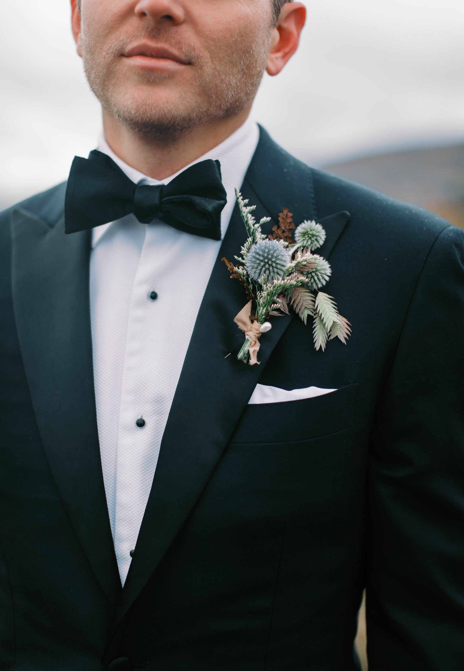 close up of a grooms wildflower boutonnière for his eclectic ranch wedding in utah. photo taken by megan robinson photography