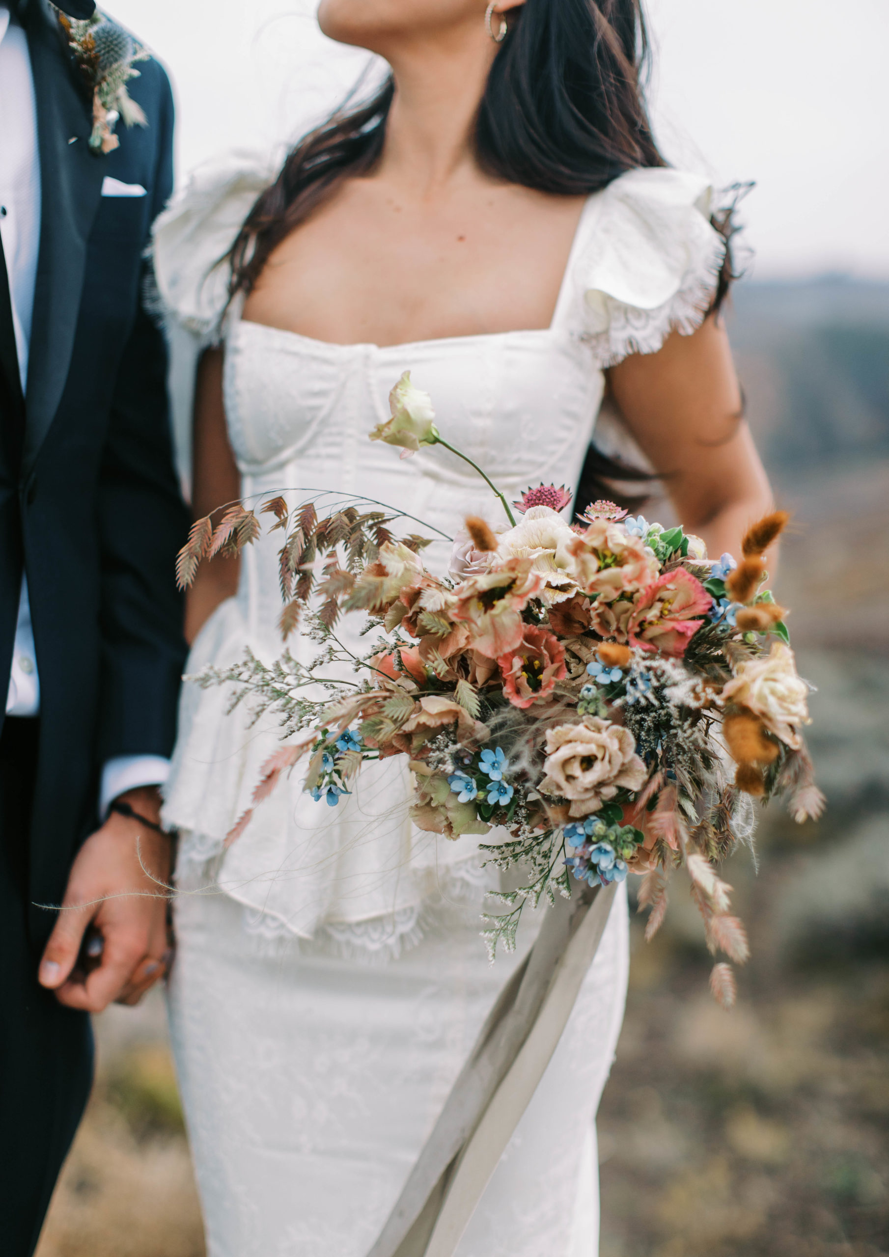 a bride holds vintage aesthetic wedding flowers. photo taken by megan robinson photography