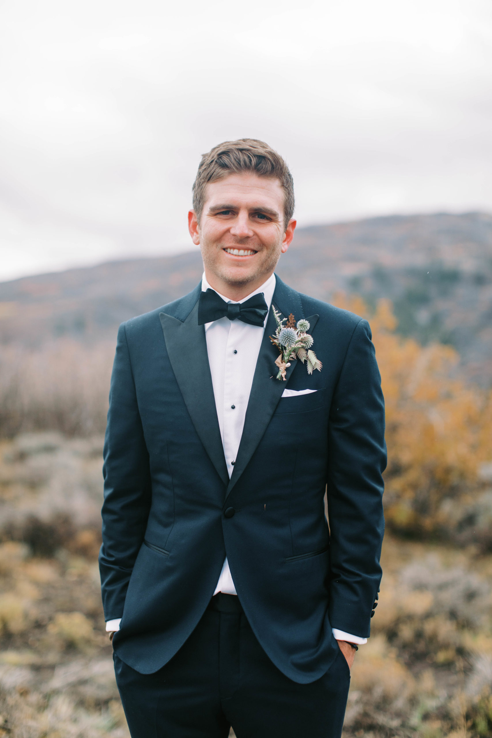 a groom smiles for the camera wearing a black wedding tuxedo. photo taken by megan robinson photography