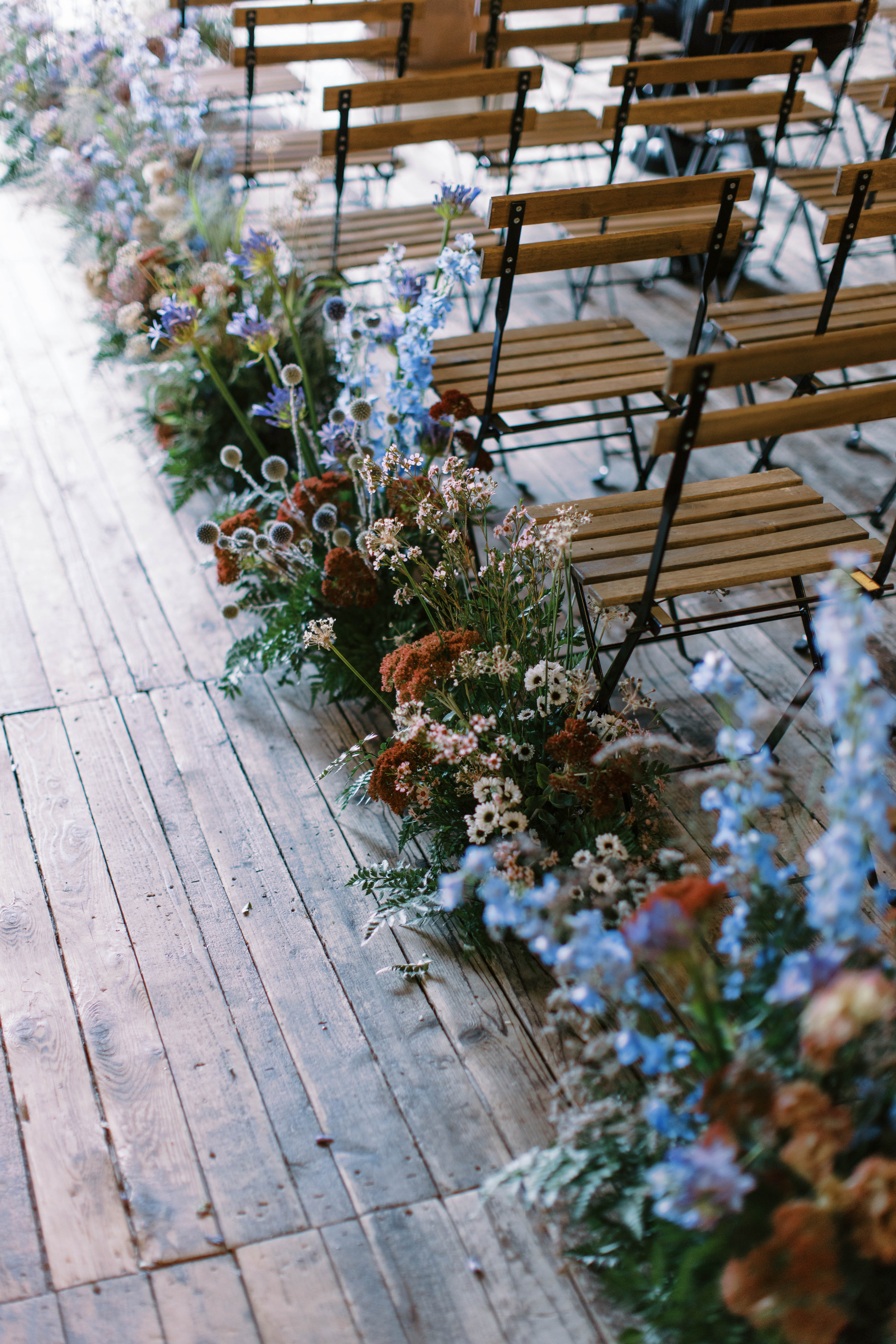 eclectic wildflower wedding flowers line the aisle at this utah ranch wedding in park city