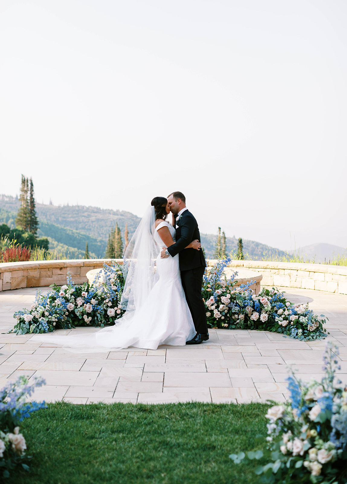 bride and groom kiss among spring aesthetic wedding flowers at montage deer valley in utah. photo taken by megan robinson photography