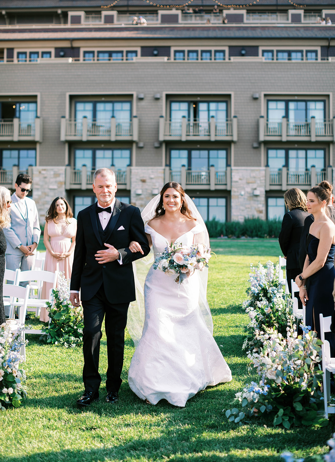 a bride walks down the aisle with her father at this outdoor montage deer valley wedding ceremony in park city. photo by megan robinson photography