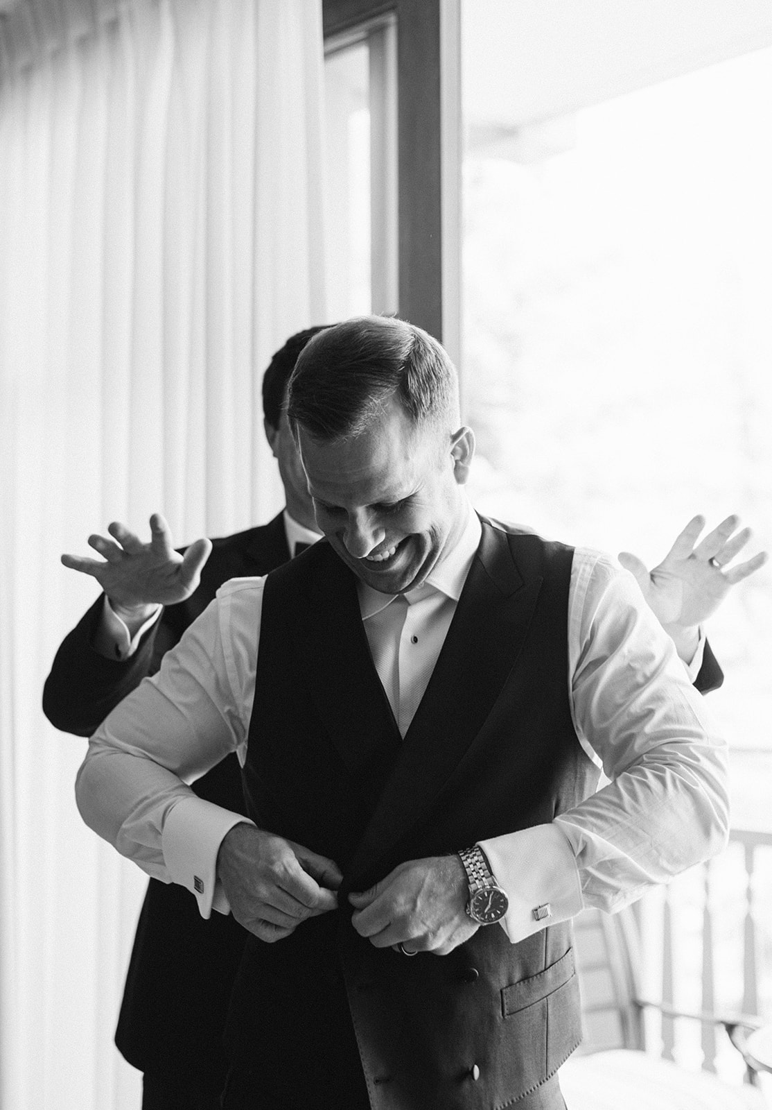 a groom gets dressed for his garden party wedding in park city utah. photo by megan robinson photography