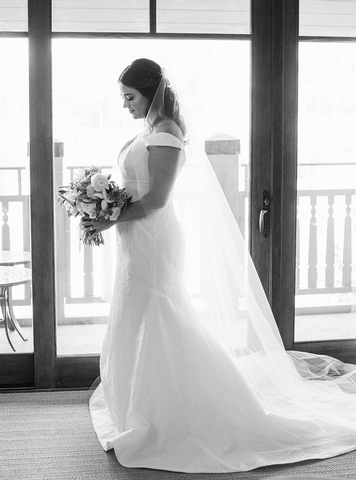 a bride poses at deer valley resort in park city after putting on her off the shoulder lace wedding dress for her garden party wedding ceremony. photo by megan robinson photography