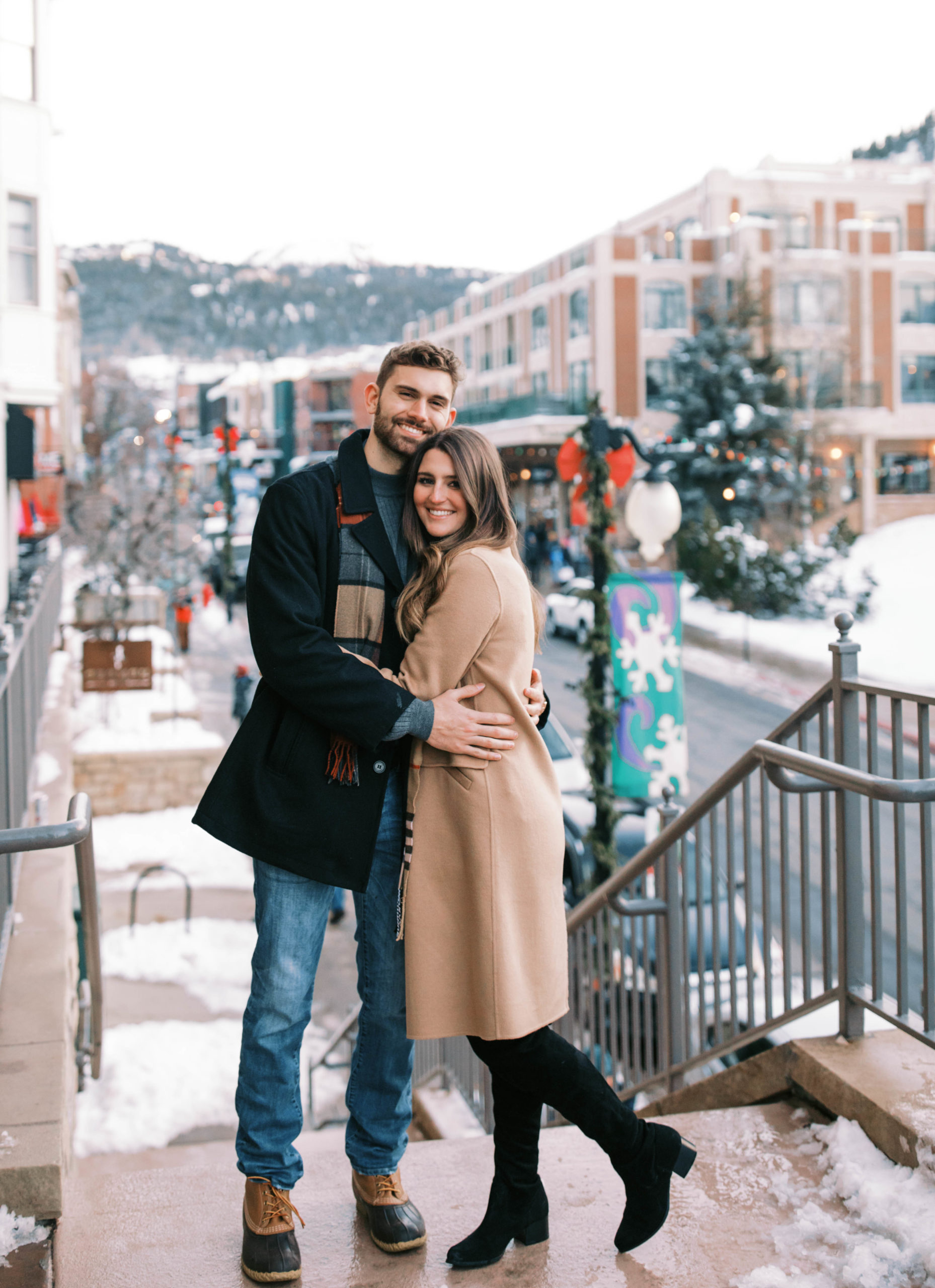 a couple poses in downtown Park City Utah for Christmas engagement photos. photo taken by Megan Robinson Photography
