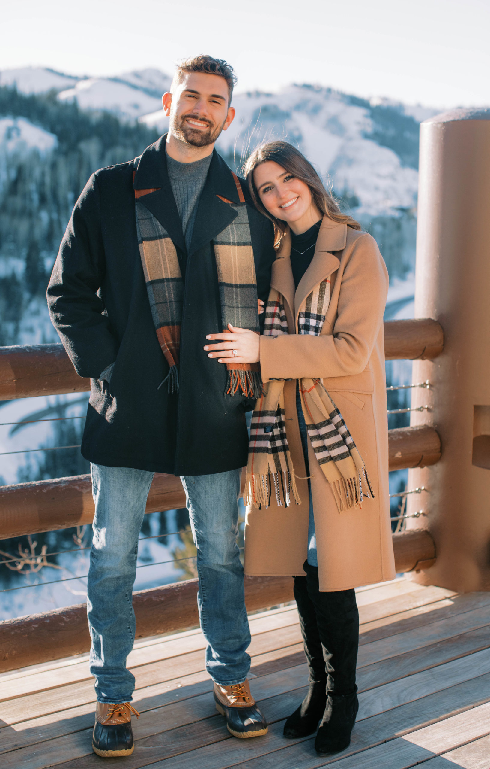a couple poses for winter engagement photos in park city utah wearing winter engagement photo outfits. photo taken by Megan Robinson Photography, park city proposal photographer