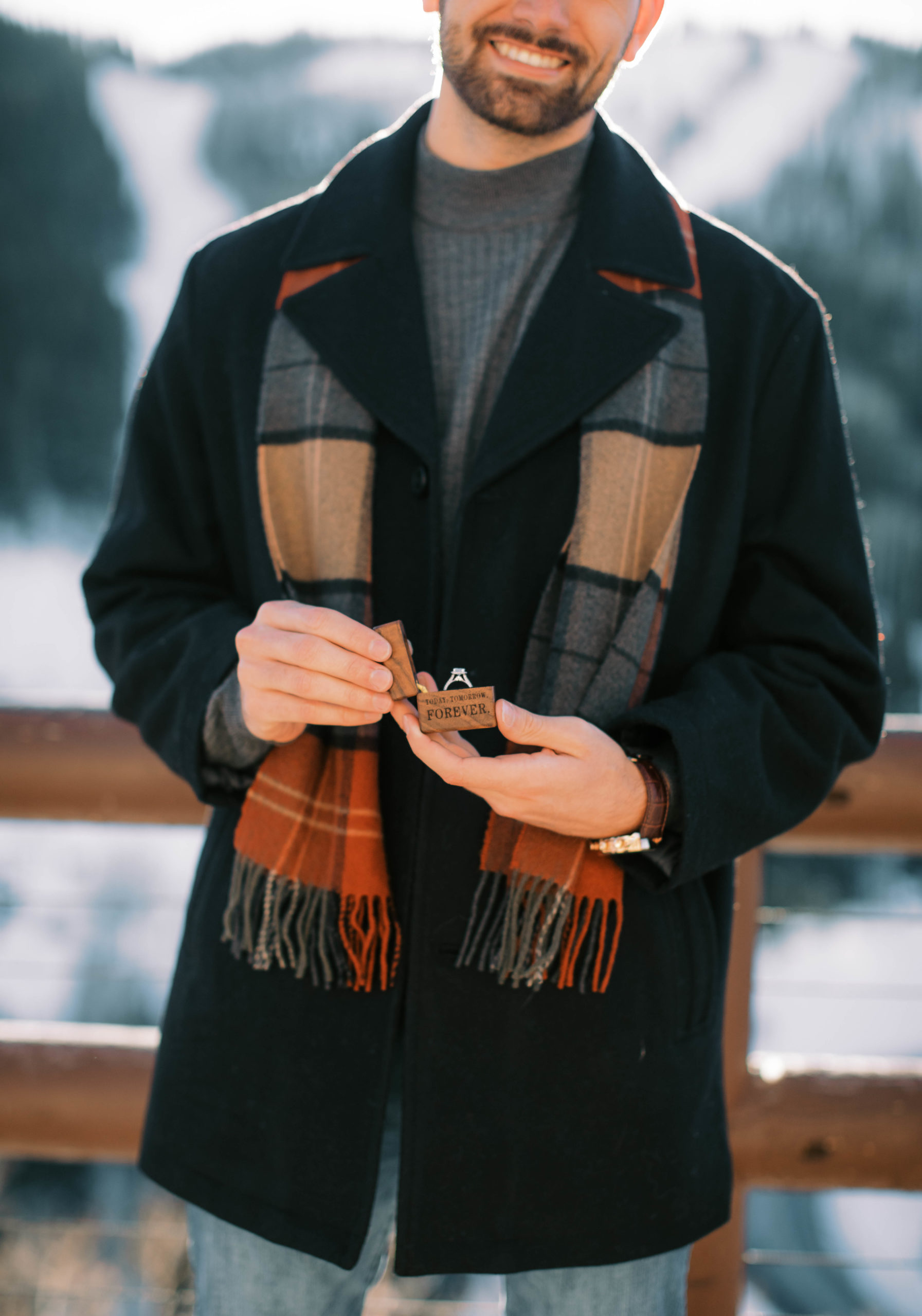 a man poses with an engagement ring box before proposing to his girlfriend at stein eriksen lodge at deer valley ski resort in park city utah. photo taken by Megan Robinson Photography