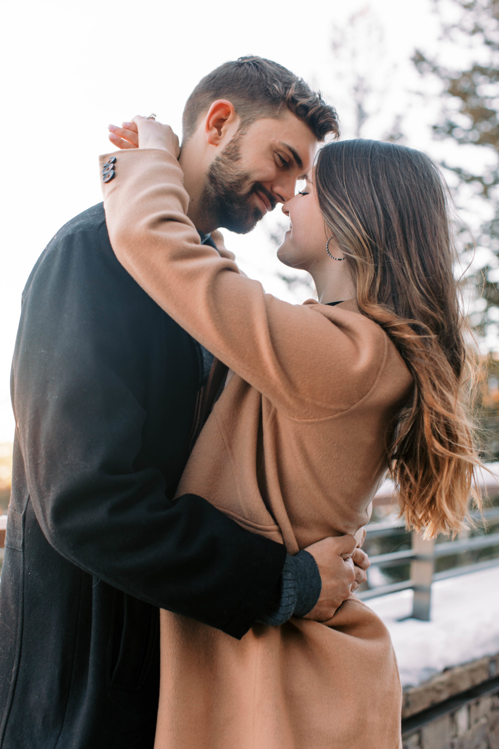 a couple kiss during their winter engagement photos after a surprise park city proposal in Utah. photo taken by megan robinson photography