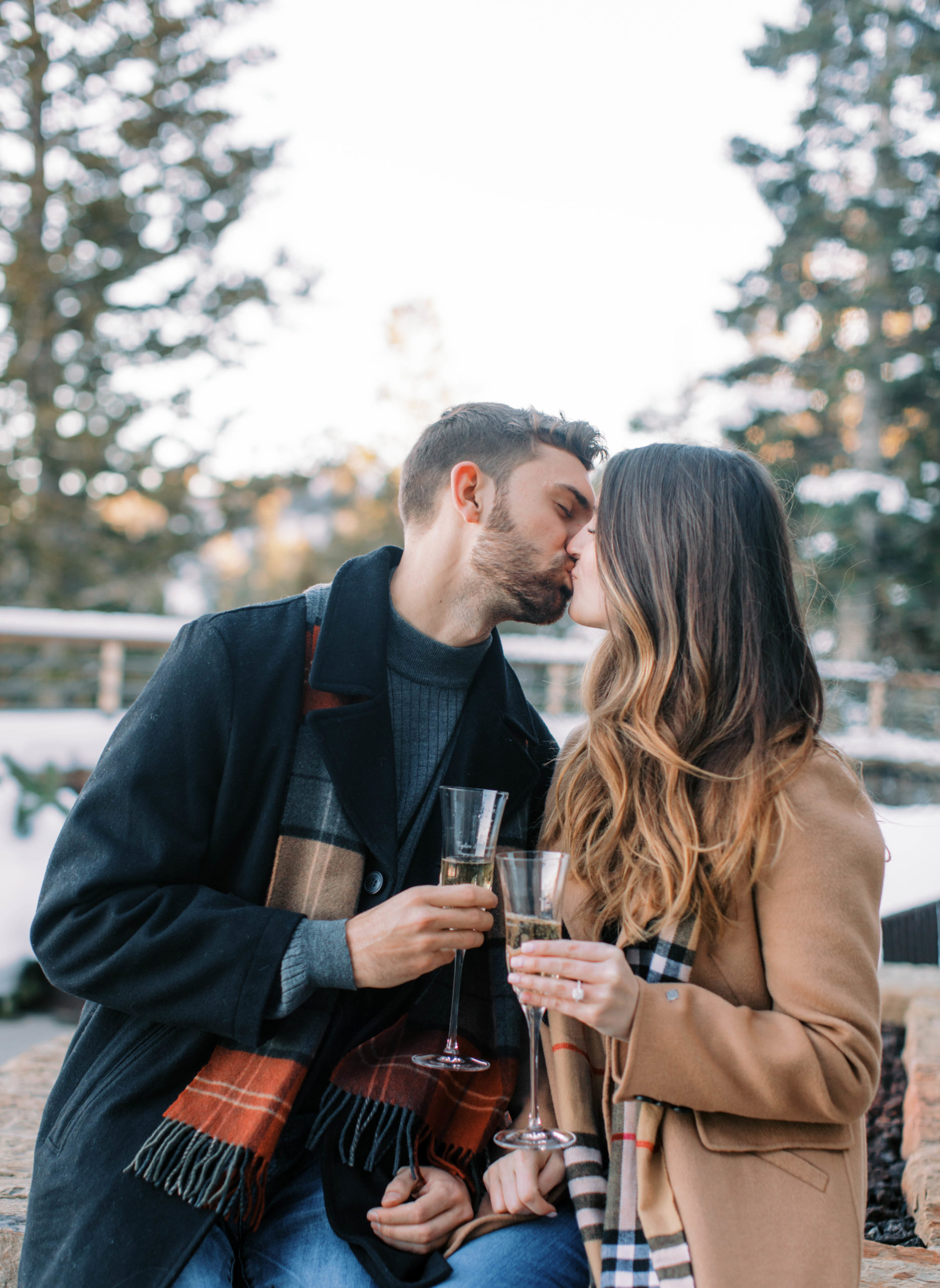 a couple kisses at deer valley ski resort just after a surprise proposal in park city. photo taken by Megan Robinson Photography