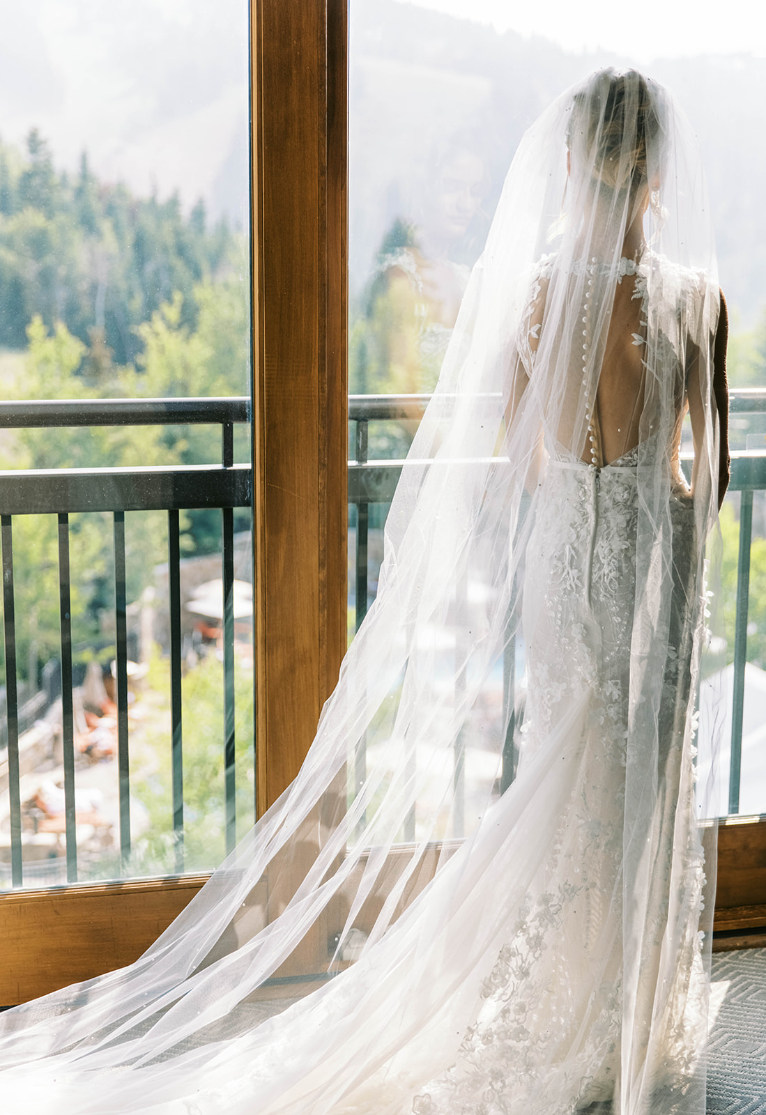 a bride puts on her lace portrait back wedding dress for the first time for her wedding at st regis deer valley in the utah mountains 