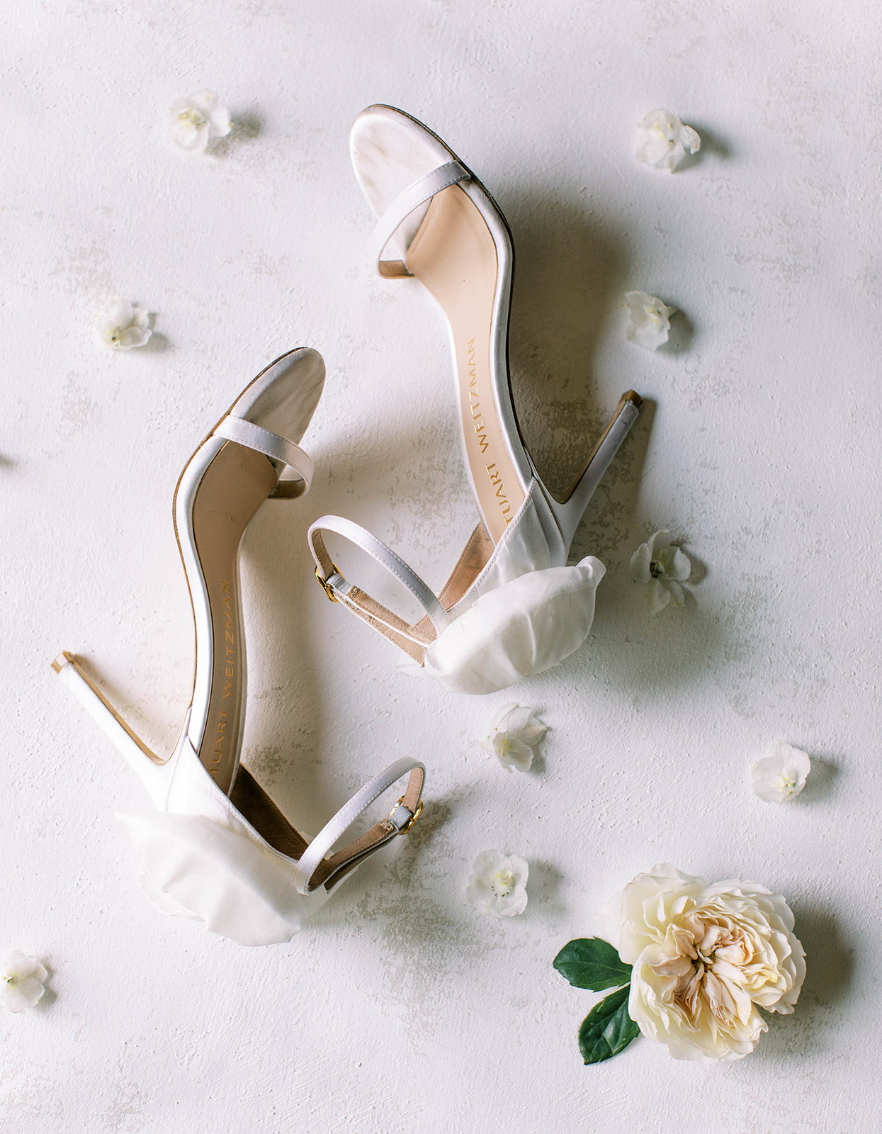 a bride's white wedding shoes with bows on the back