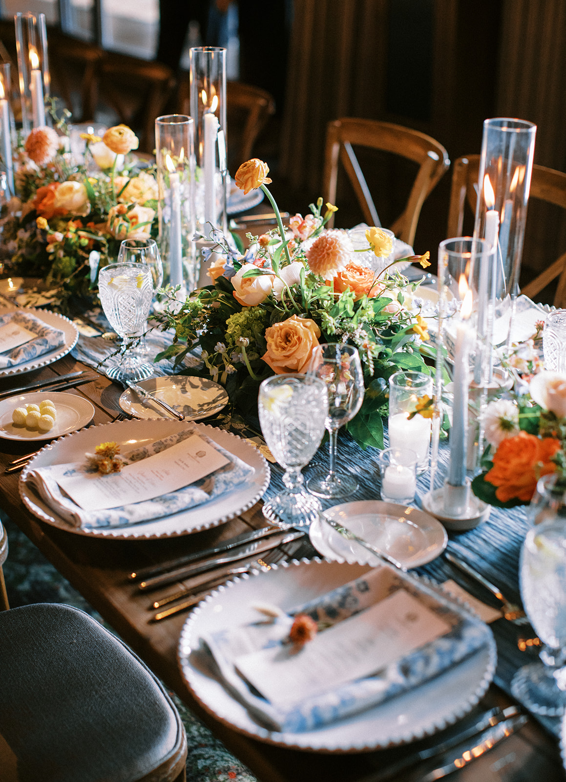 wedding table decorations with a colorful wedding palette including bright blue and orange flowers, blue linens and candles 