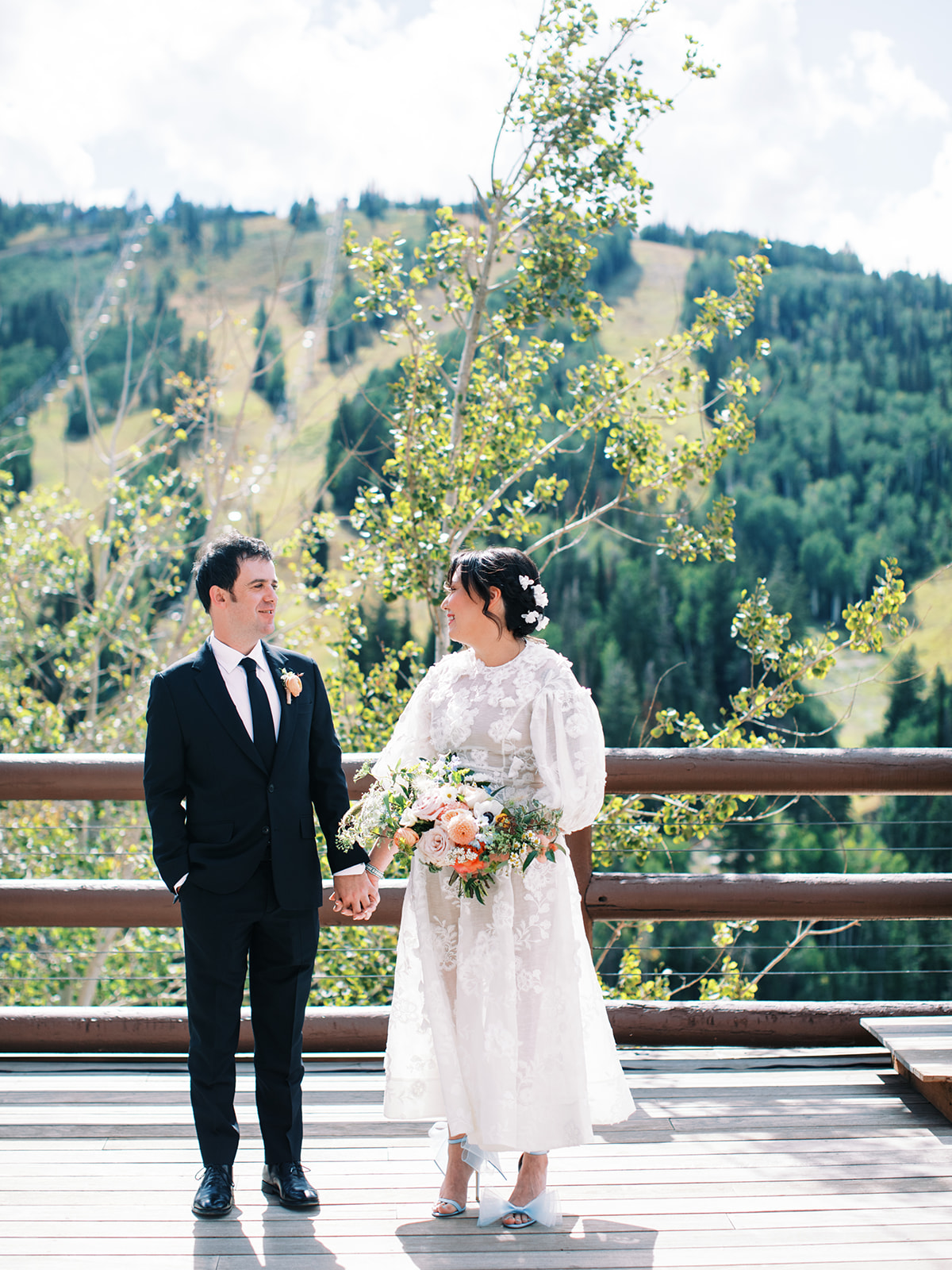 a bride and groom hold hands at their summer wedding in park city utah