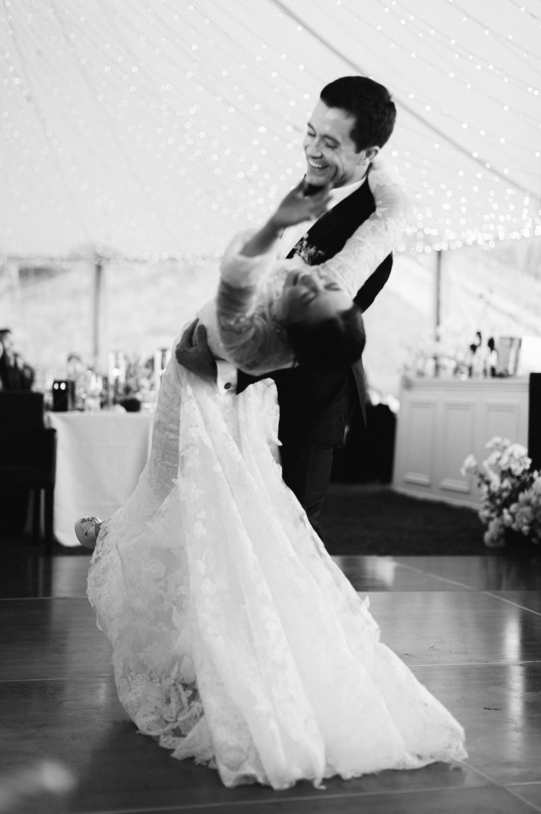 couple dances at their wedding reception black and white