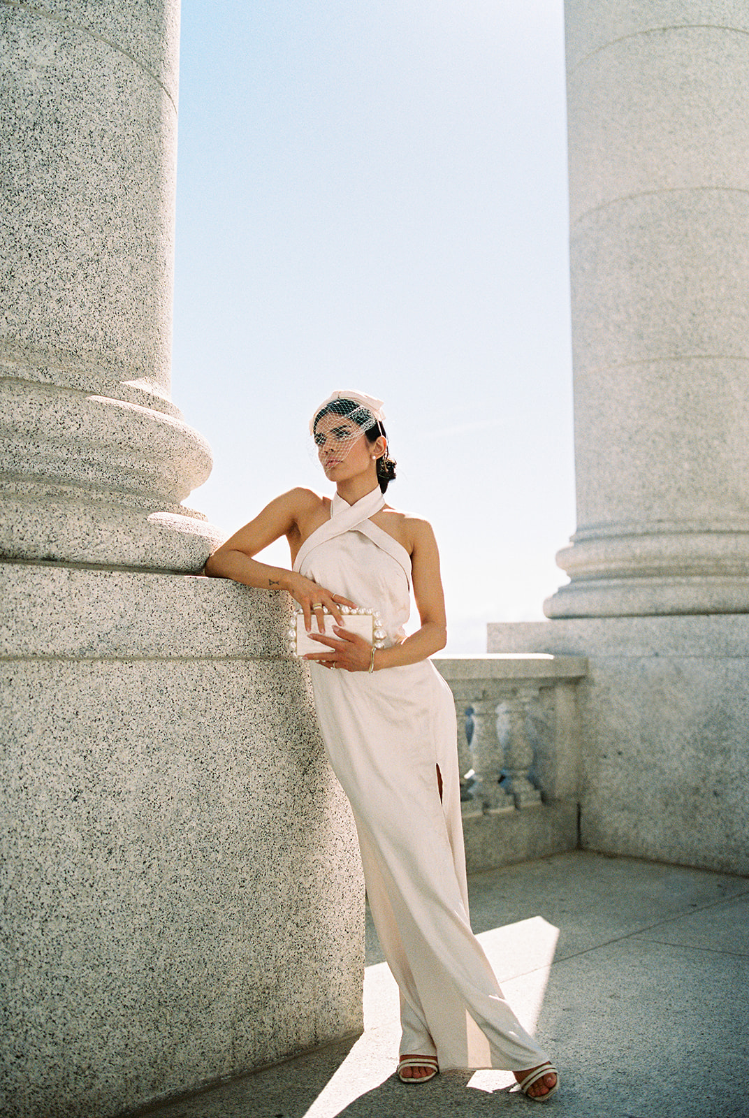 a bride poses in a silk wedding dress outside the utah capitol building