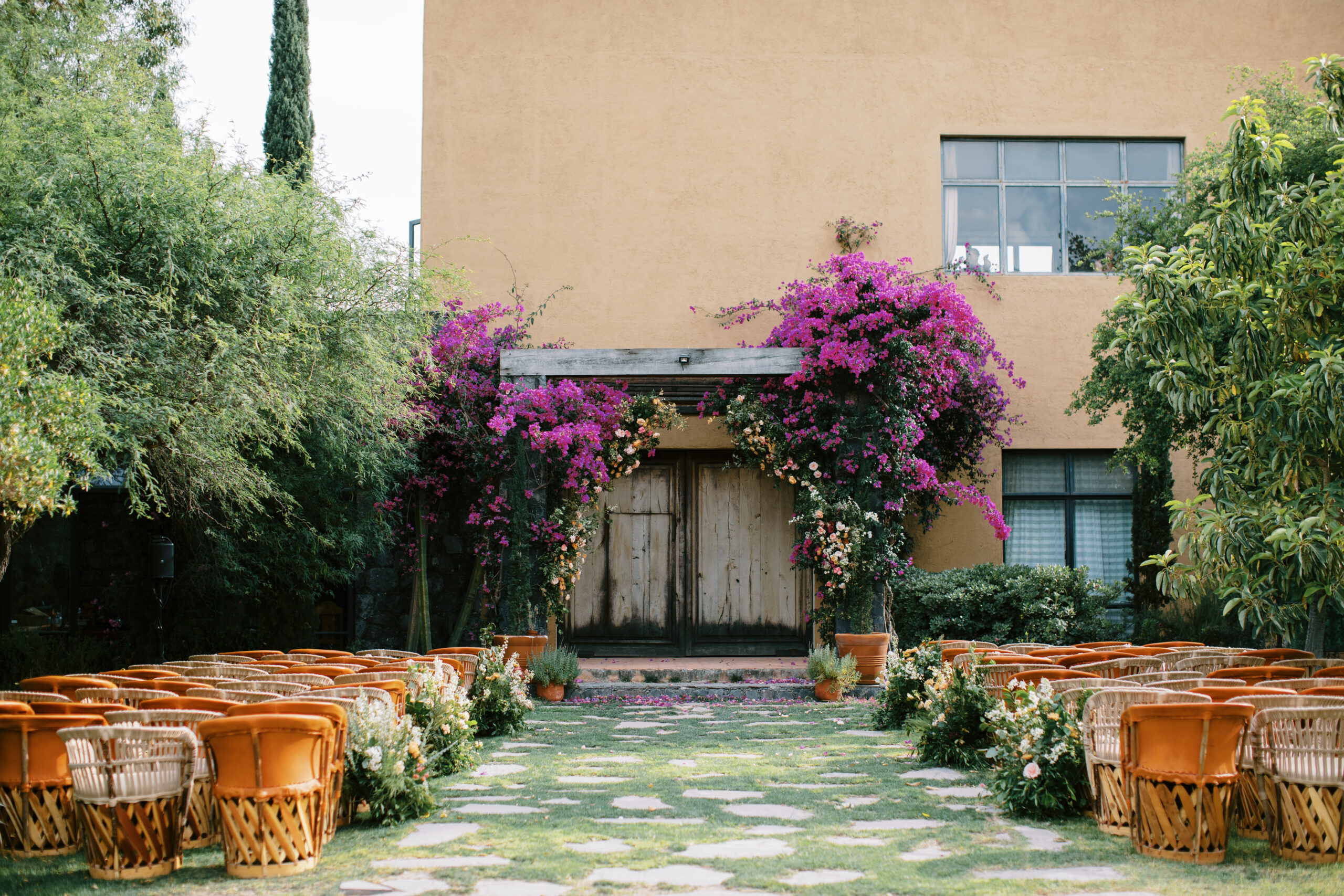 purple lush bougainvillea trees in a green ceremony space in Mexico